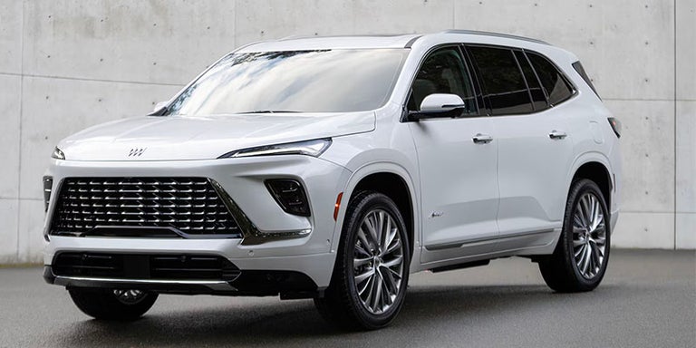 Three-Quarter View of a White 2025 Buick Enclave Surrounded by a Wall