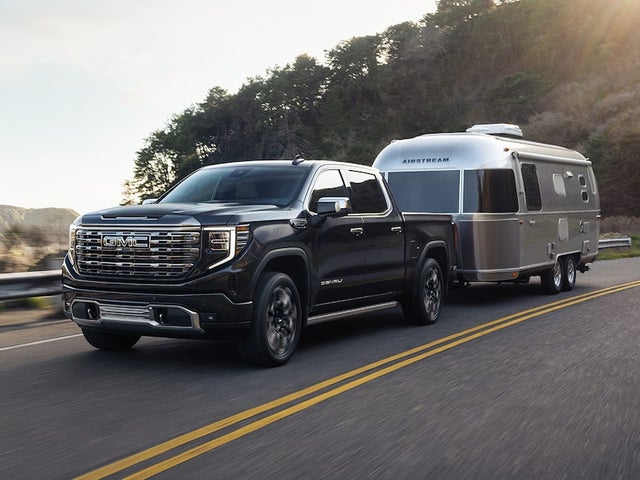 GMC Sierra Denali Towing an Airstream RV Down the Road