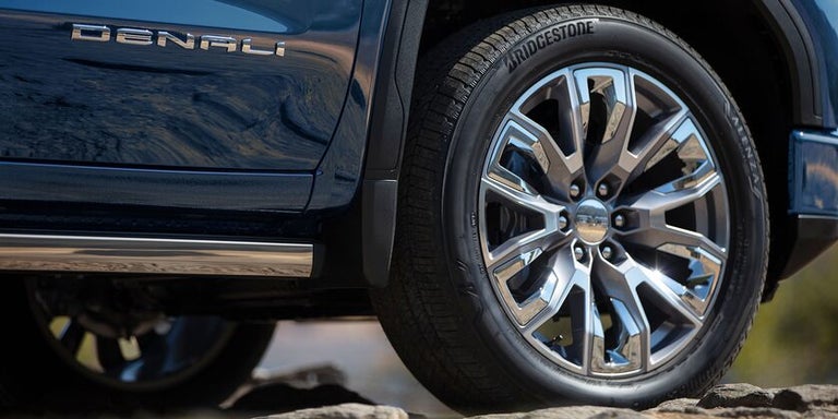 Close-up of the GMC 2025 Sierra 1500 Denali front passenger-side chrome wheel