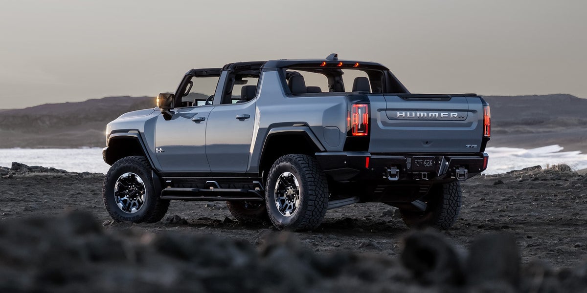 A Rear Profile view of the GMC HUMMER EV Pickup Truck with a Sunset